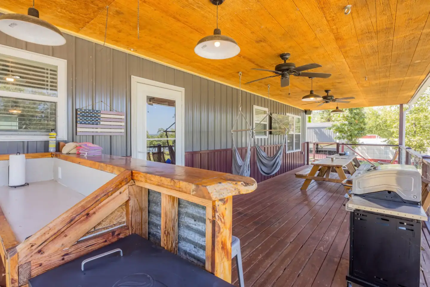 The back porch with hammock chairs, outdoor bar, and lake view